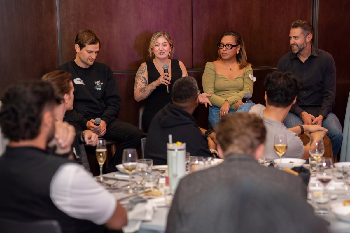 panel discussion wireless microphone corporate dinner raleigh - Audio Four-person panel discussion with wireless handheld microphone at corporate awards banquet dinner, featuring audience engagement at round tables with wine service